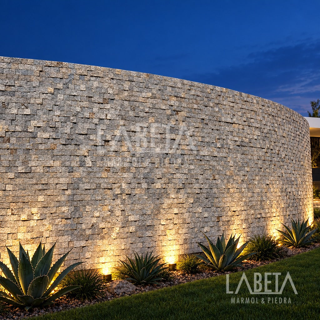 Muro curvo de Adoquín Gris Diamantado iluminado de noche con luz rasante — ambientación digital sobre instalación real | Piedras Labeta