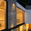 Fachada con Fachaleta Gris Diamantada iluminada de noche — ambientación digital sobre instalación real | Piedras Labeta