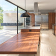 Cocina con piso y muros de Mármol Travertino en luz de mañana — ambientación digital sobre instalación real | Piedras Labeta