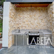 Piedra Dorada Diamantada en asador de casa moderna con jardín | Recubrimiento piedra natural dorada | Piedras Labeta