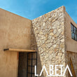 Fachada residencial con Piedra Dorada laja irregular en muro — casa moderna con recubrimiento natural dorado | Piedras LABETA
