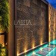 Muro de Recinto Cincelado al atardecer con iluminación arquitectónica — ambientación digital sobre instalación real | Piedras Labeta